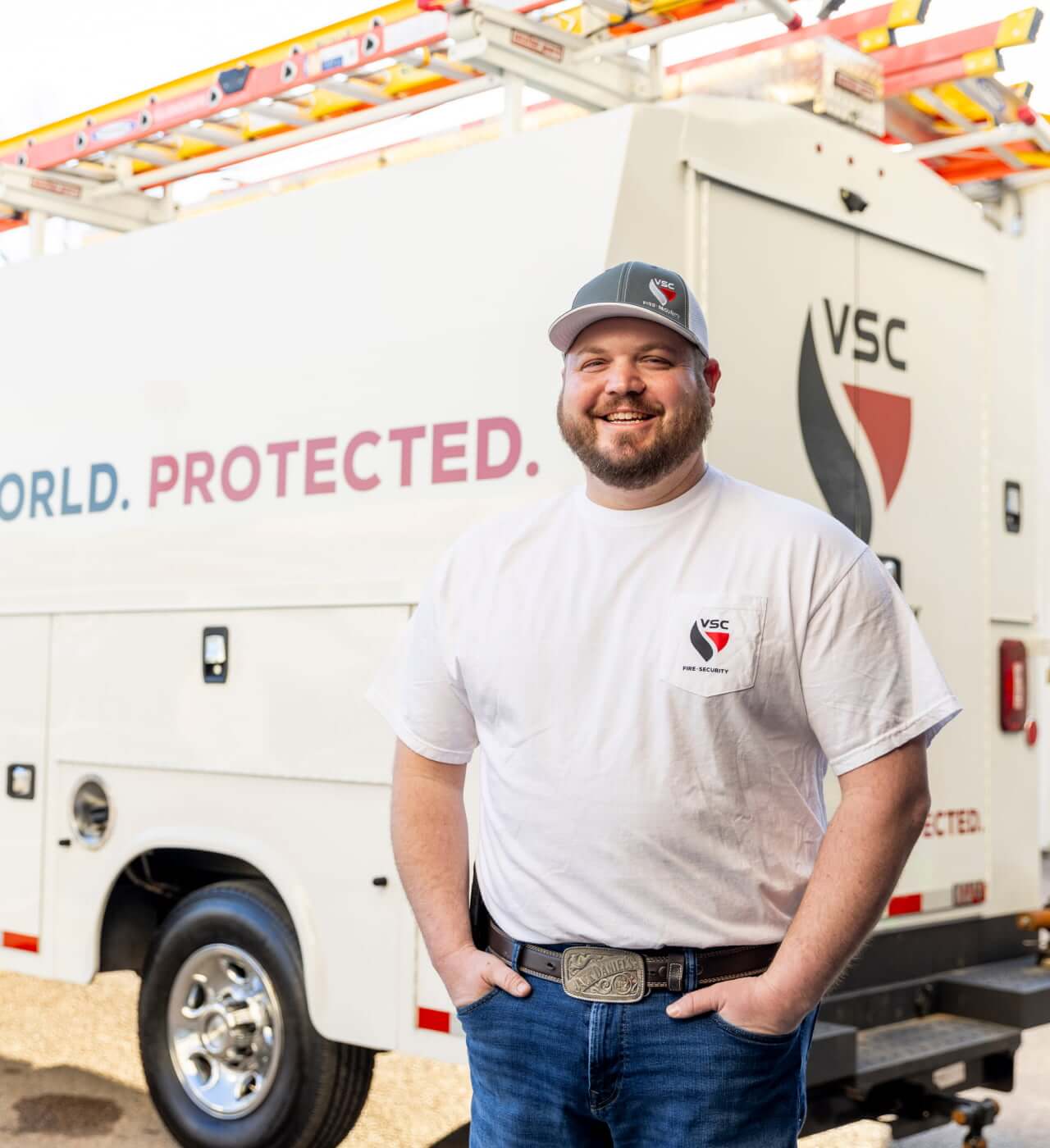 VSC service technician standing beside a commercial service truck outdoors.